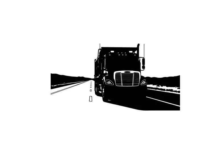 Silhouette of a semi truck driving on a highway