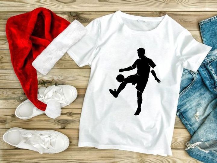 Silhouette of a soccer player kicking a ball in mid action