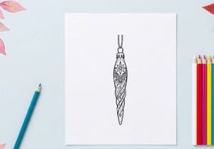 Silver glitter Christmas teardrop ornament with etched wolf design hanging on tree branch