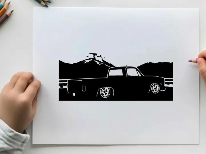 Silhouette of a pickup truck in front of mountains