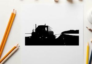 Silhouette of a semi truck driving on a highway at dawn or dusk