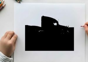 Silhouette of a semi truck driving on a road with mountains