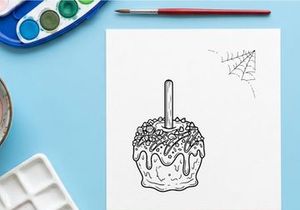 Halloween candy apple coloring page. Spooky caramel apple line art for kids activity.