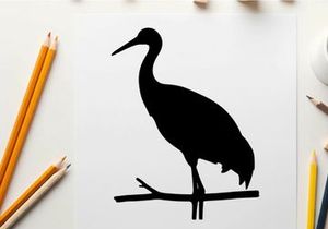 Silhouette of a heron perched on a branch in profile view