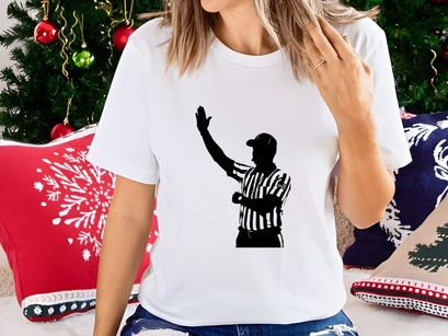 Silhouette of a referee in a black and white striped uniform signaling a call