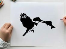 Silhouette of a bird catching a fish in mid air