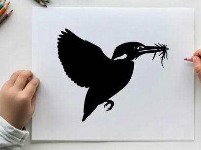 Silhouette of a bird in flight with twigs in its beak