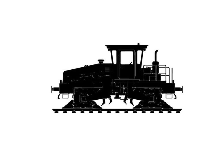 Silhouette of a caterpillar tractor on railroad tracks