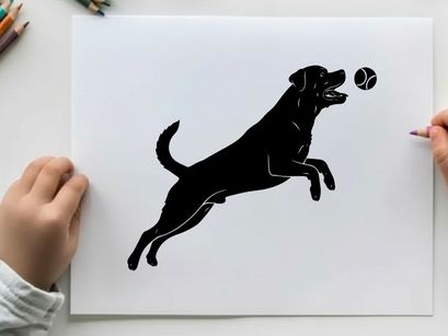 Black silhouette dog jumping for a ball in mid air silhouette