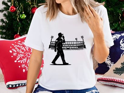 Silhouette of a man walking in front of a sports stadium at night