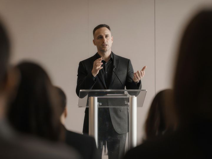 Man speaking on a podium in front of people