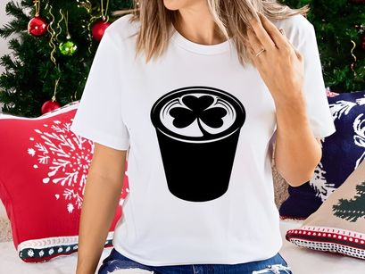 Black coffee cup with white shamrock foam design isolated