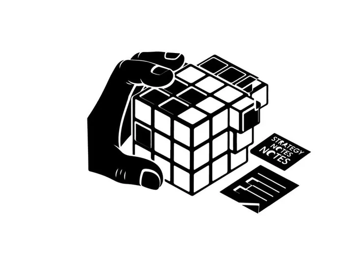 Silhouette of hand holding a rubik's cube with notes