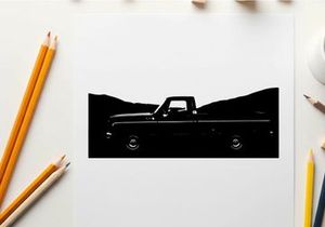 Silhouette of a classic pickup truck against a mountainous backdrop silhouette