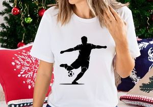 Silhouette of a soccer player kicking a ball in mid action