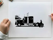 Silhouette of a man standing beside a large semi truck