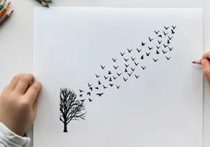 Silhouette of birds flying from tree on white and yellow background silhouette
