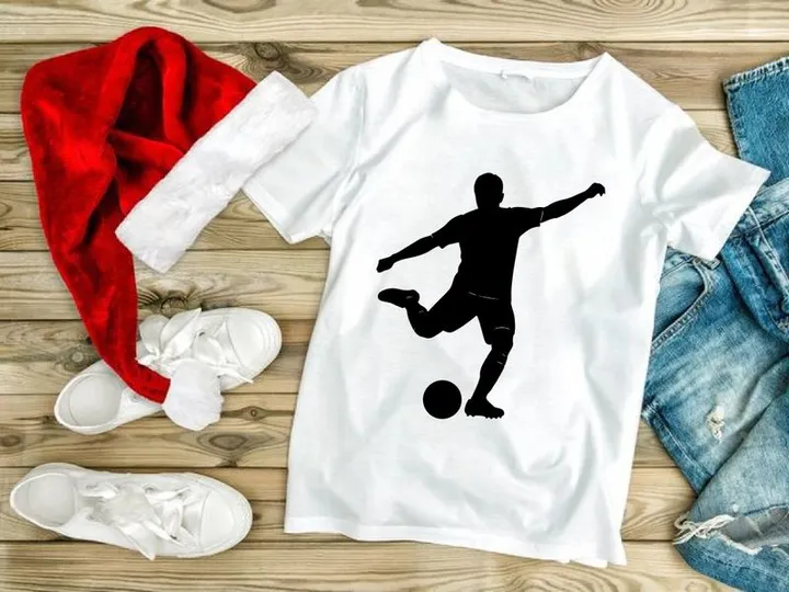 Silhouette of a soccer player kicking a ball in mid action