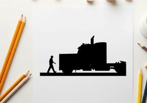 Silhouette of a man walking beside a large semi truck