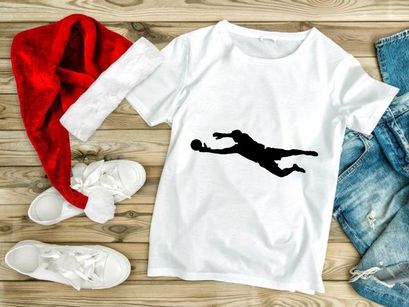 Silhouette of a soccer goalkeeper diving to catch a ball in mid air motion