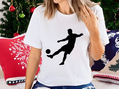 Silhouette of a soccer player kicking a ball in mid action