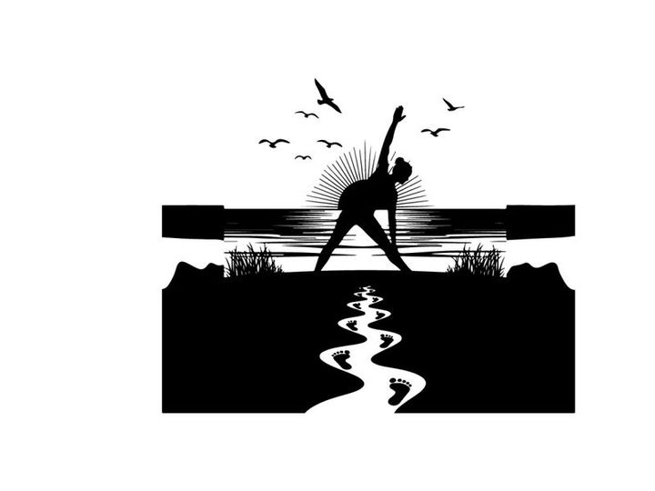 Silhouette of a person practicing yoga near a serene body of water with birds