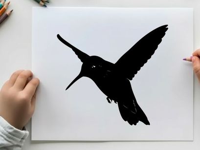 Silhouette of a hummingbird in flight with extended wings and beak