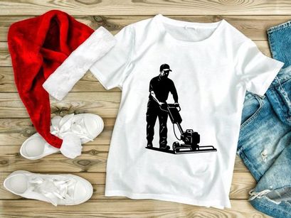 A man operating a plate compactor on a construction site with safety gear