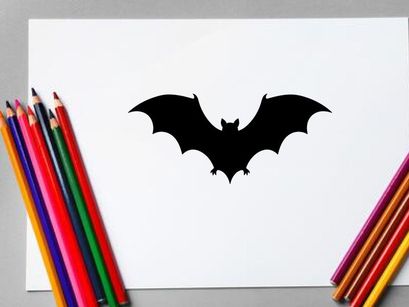Silhouette of a Bat Flying with Spread Wings in Dark Night Scene