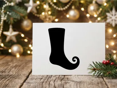 Black silhouette of a Christmas elf shoe or curly toe boot isolated on white background