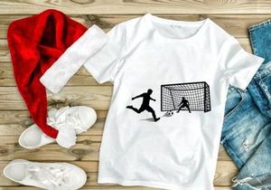 Soccer player kicking ball past goalie