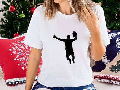 Silhouette of a man playing volleyball in mid air