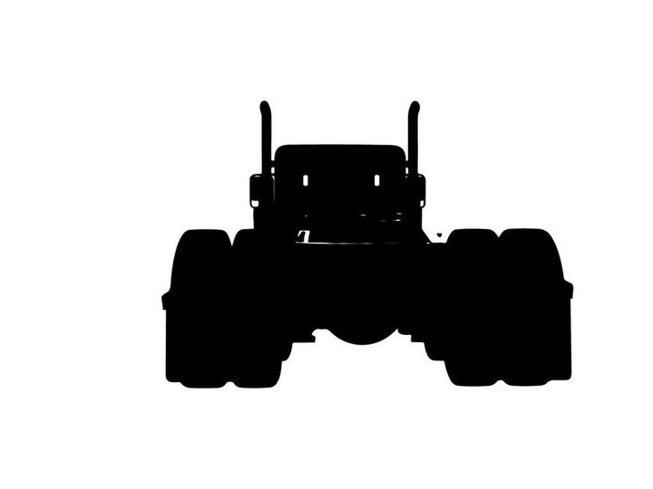 Silhouette of a large truck with oversized tires and exhaust pipes