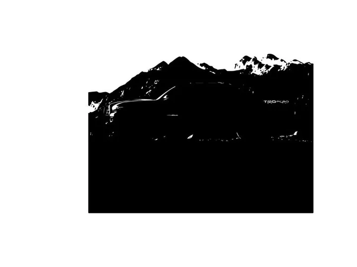 Silhouette of a pickup truck in front of a mountain range