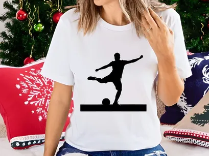 Silhouette of a soccer player kicking a ball in mid action with arms outstretched