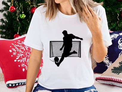 Soccer player kicking ball in front of goal net in action