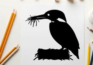 Silhouette of a kingfisher bird with twigs in its beak profile view