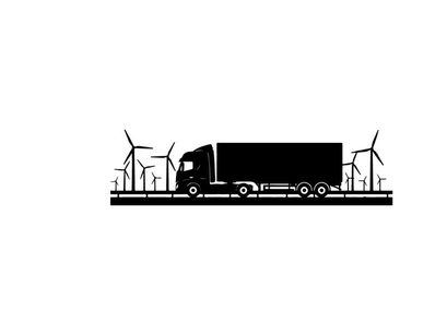 Truck silhouette driving past wind turbines on a sunny day