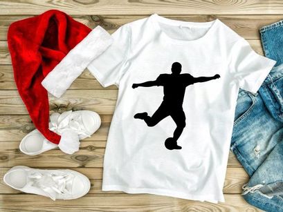 Silhouette of a soccer player kicking a ball in mid action