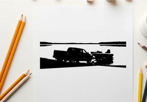 Silhouette of a pickup truck towing a boat on a road by the water
