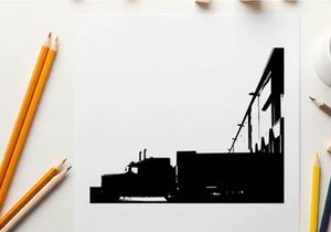 Silhouette of a semi truck parked beside a large building