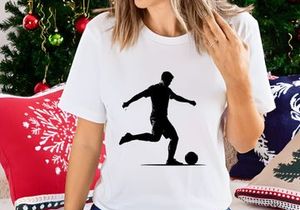 Silhouette of a soccer player kicking a ball in motion