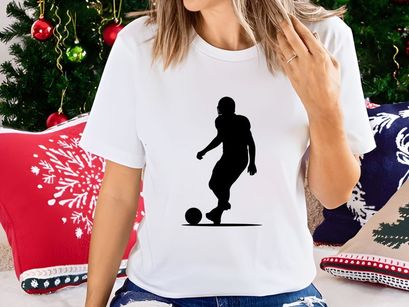 Silhouette of a soccer player kicking a ball in motion
