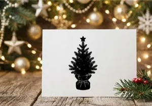 Black silhouette of a small Christmas tree with a star topper isolated on white background
