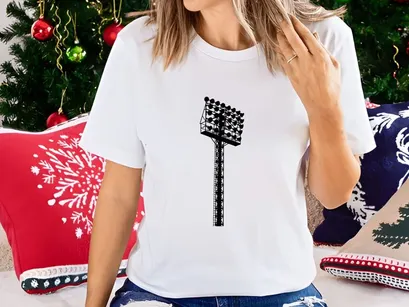 A tall stadium light pole with multiple lights on top against a gray sky