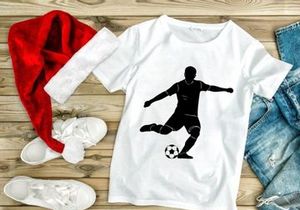 Silhouette of a soccer player kicking a ball in mid action