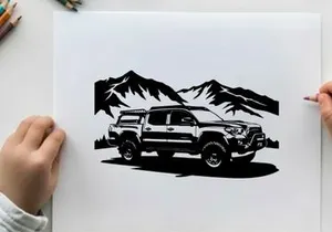 Silhouette of a rugged pickup truck in front of majestic mountains