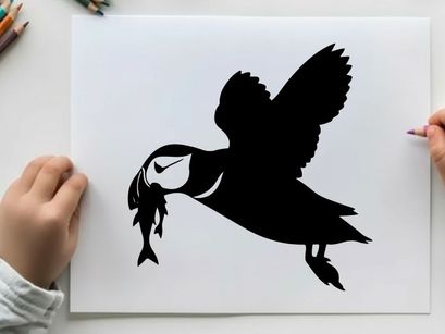 Silhouette of a puffin flying with a fish in its beak outdoors