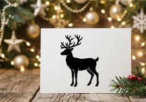 Black silhouette of a reindeer with large antlers isolated on a white background