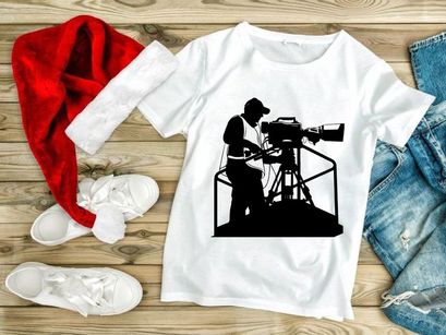 Silhouette of a cameraman operating a large video camera on a tripod stand